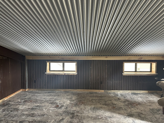 Barndominium bonus room with corrugated metal ceiling and wainscoting in central Oklahoma