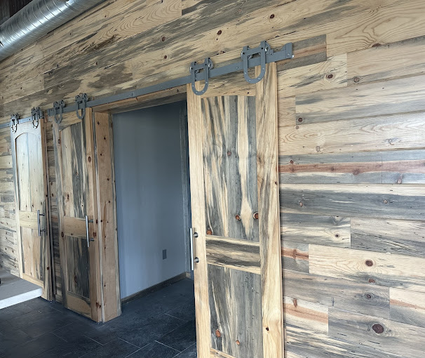 Sliding barn doors and blue pine plank walls inside a barndominium near Wewoka, OK