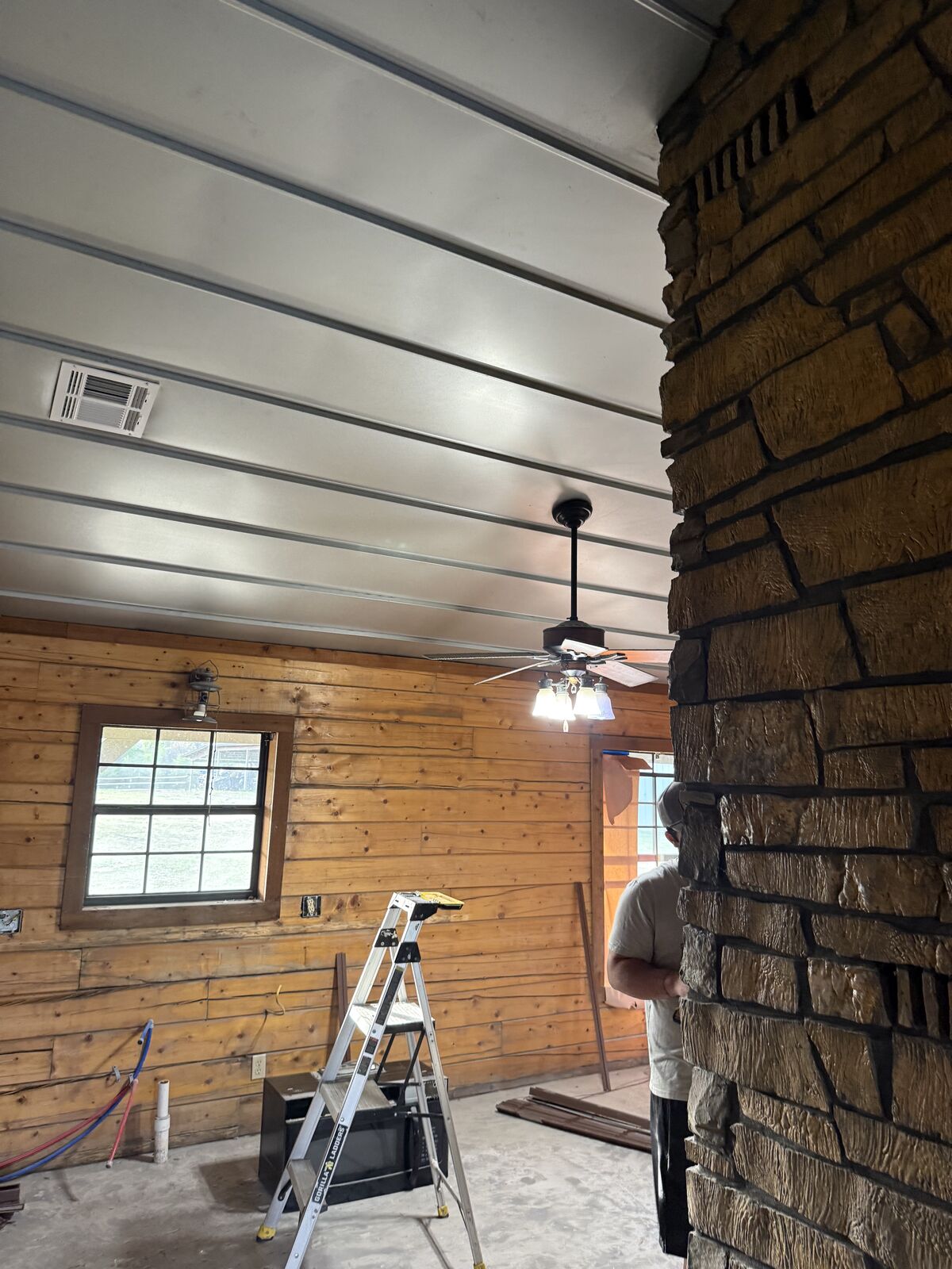 Barndominium interior with hickory wood walls and stone fireplace near Wewoka, OK