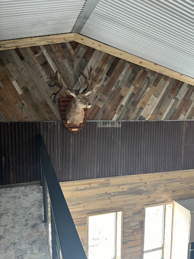 Barndominium loft with vaulted reclaimed wood ceiling and metal accent walls in Oklahoma