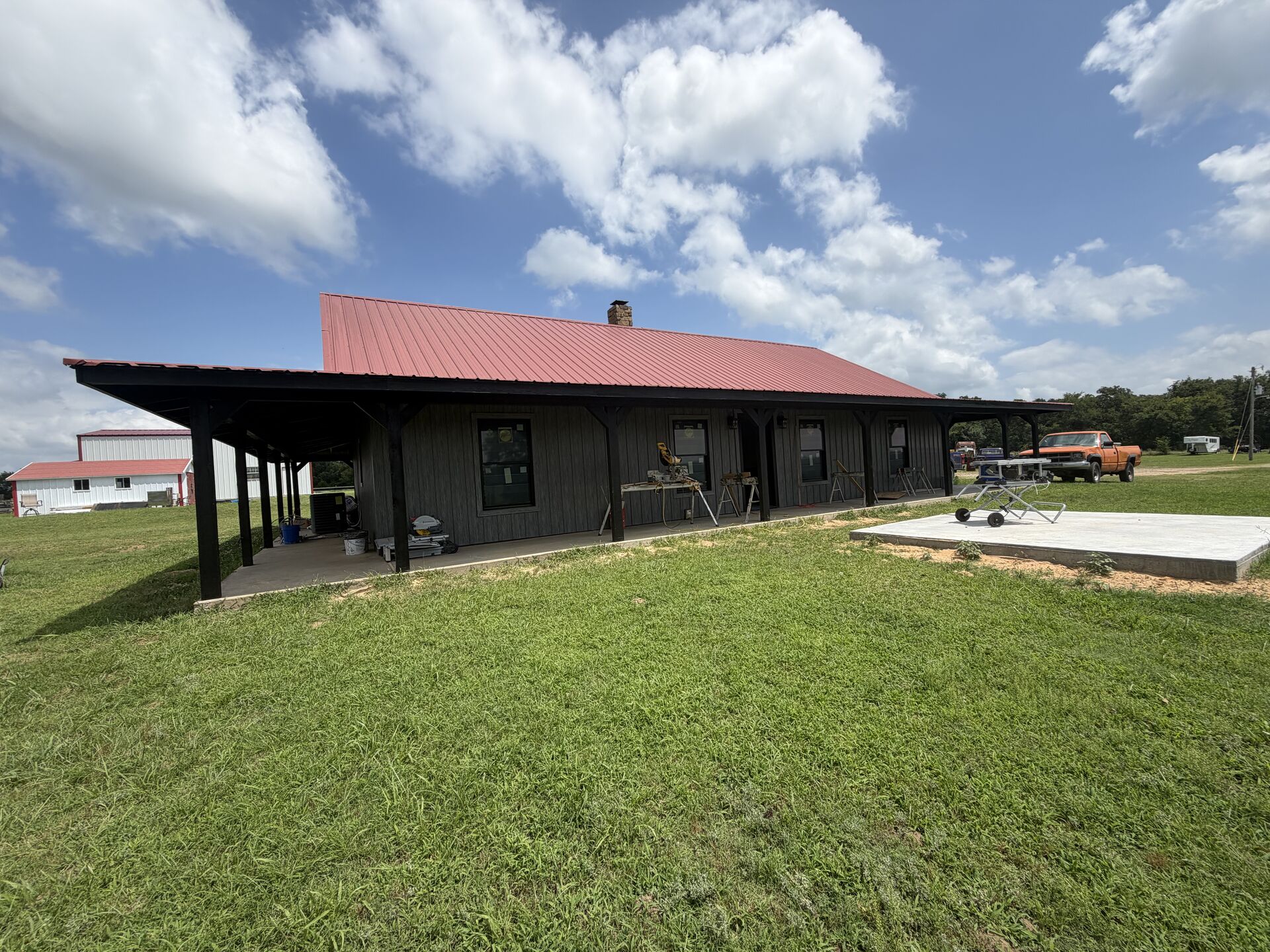 Custom barndominium with red metal roof built by Smith Construction Services near Wewoka, OK