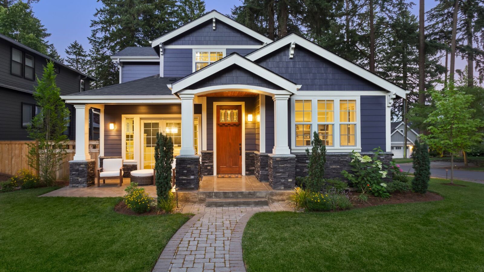Craftsman-style home with new windows and inviting front door at dusk