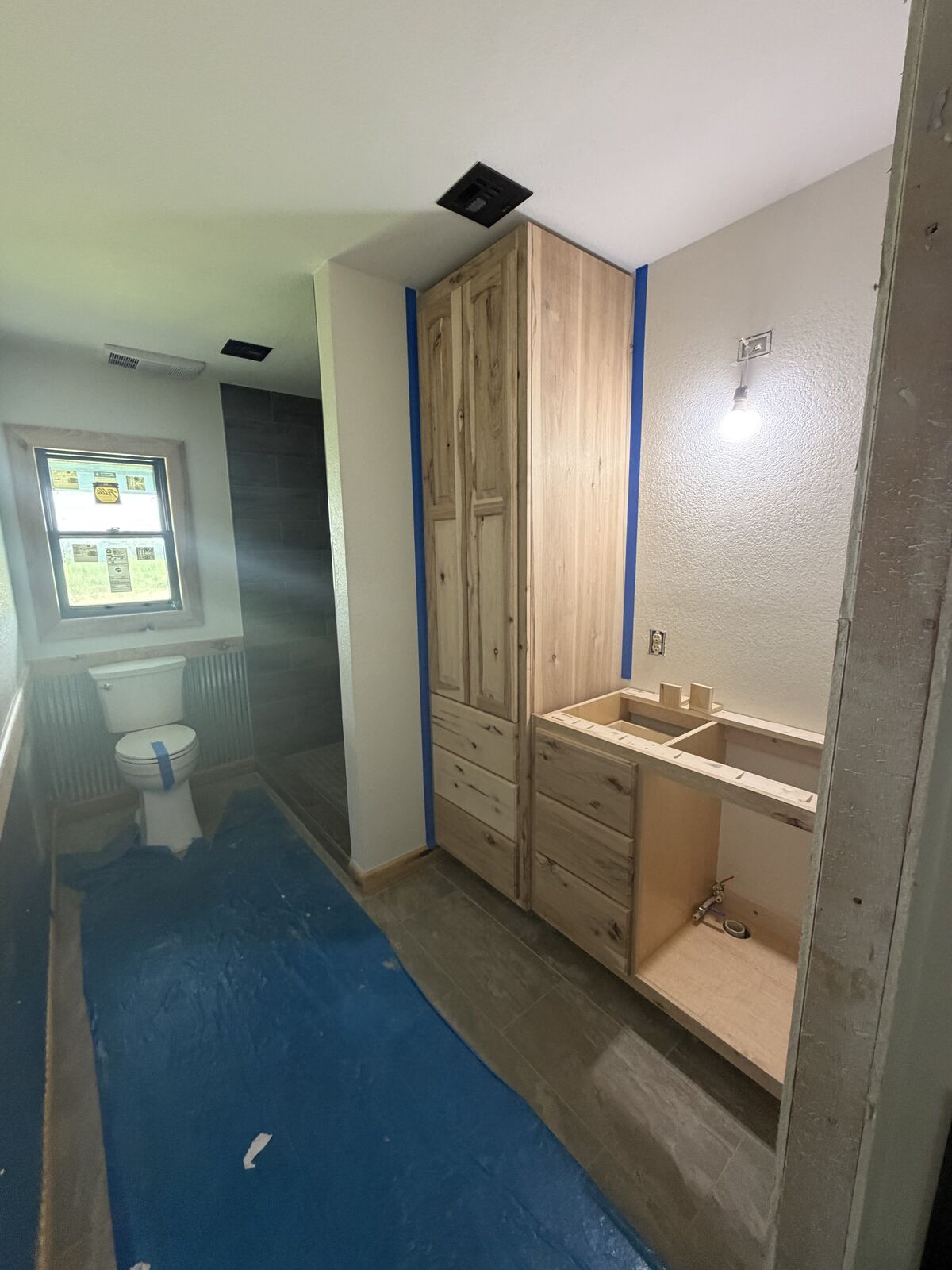 Custom hickory bathroom cabinets and linen tower built by Smith Construction in Oklahoma