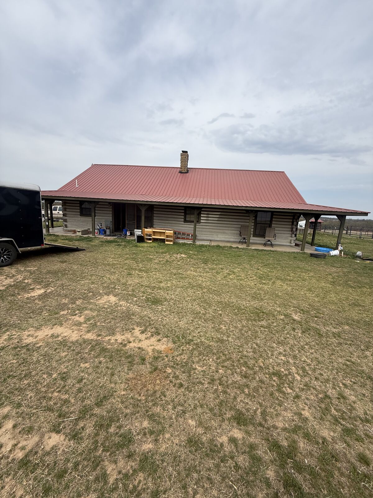 Custom log-sided home with red metal roof built near Shawnee, Oklahoma