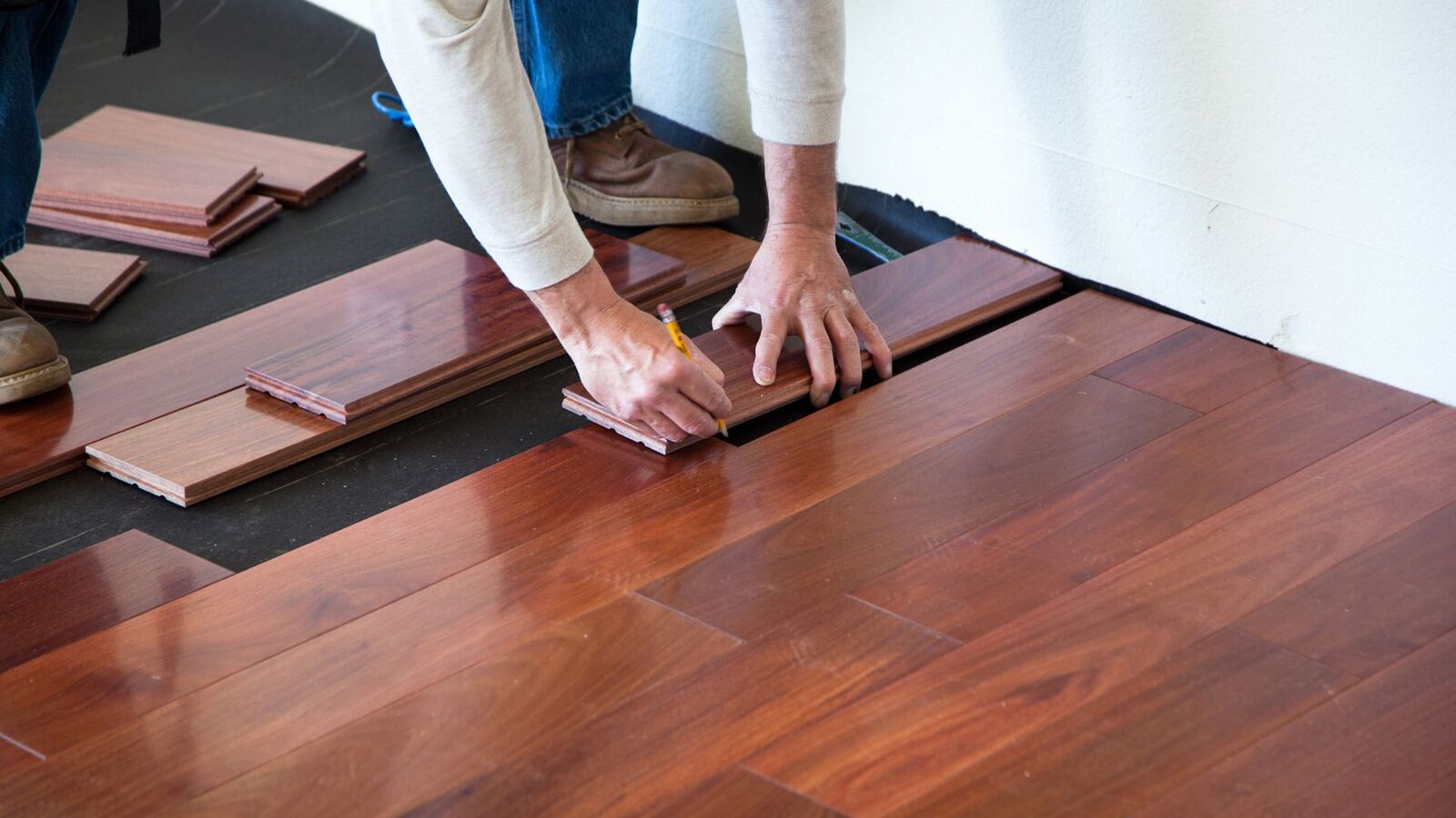 Craftsman installing hardwood flooring during a remodel