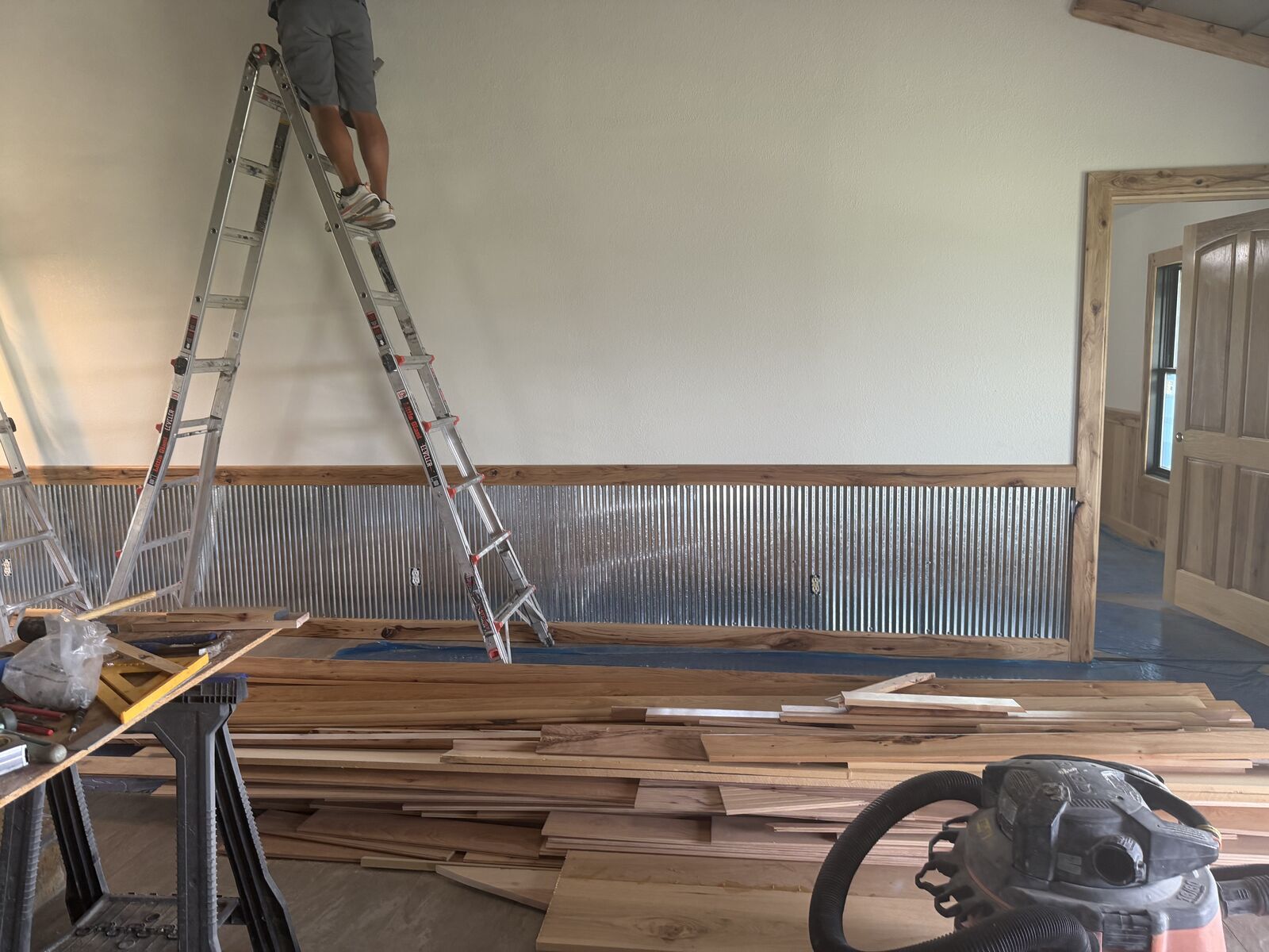 Crew installing corrugated metal wainscoting during a custom interior project in Oklahoma