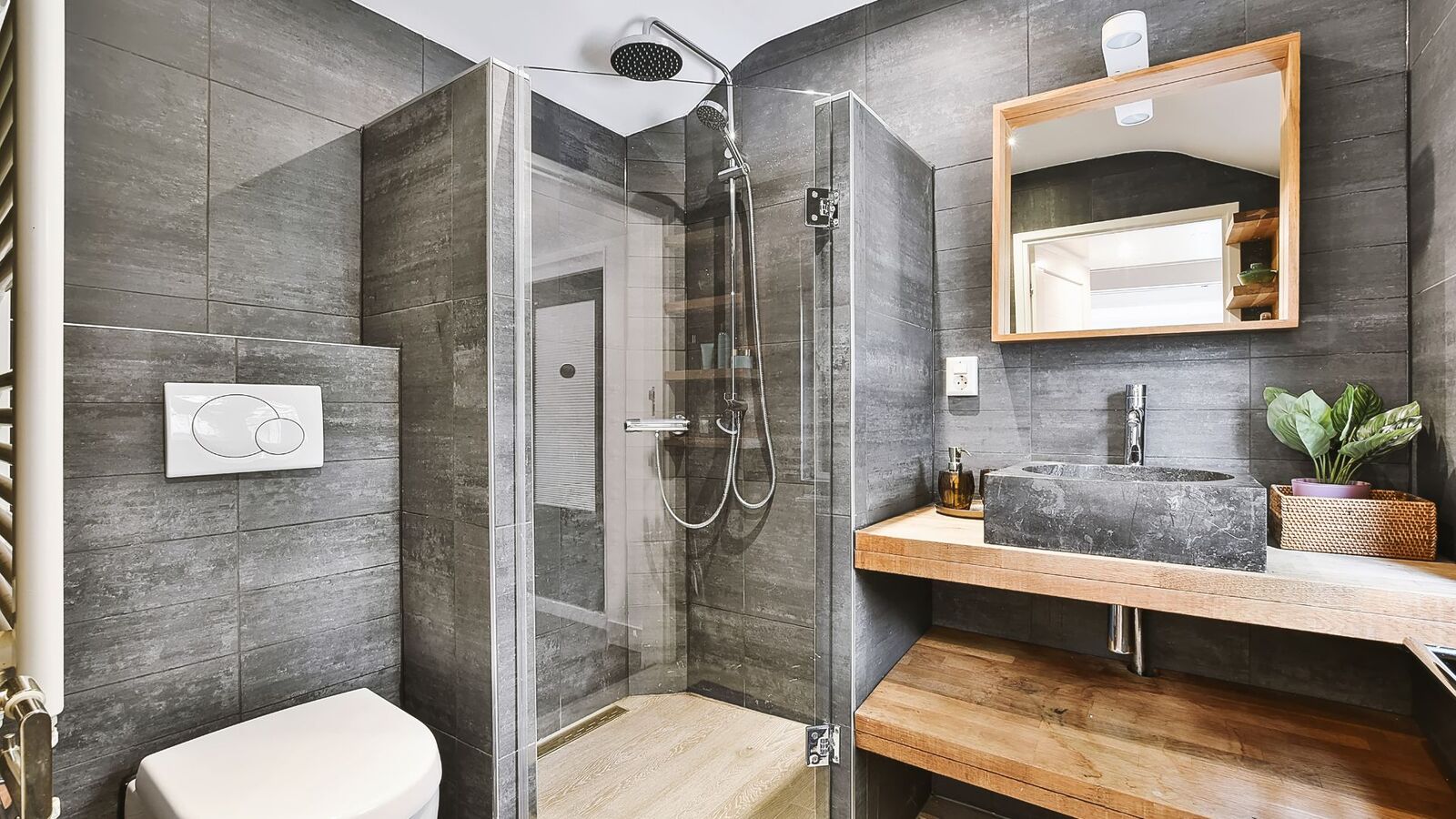 Modern gray bathroom renovation with tiled shower and wood vanity
