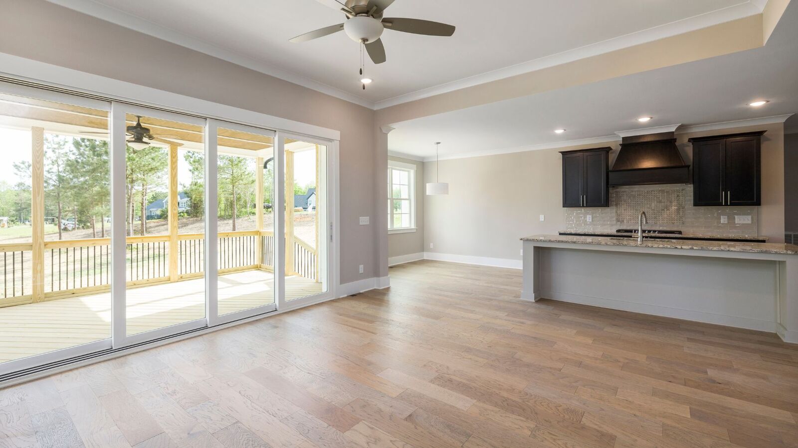 Open-concept living and kitchen space in a newly built home with porch access