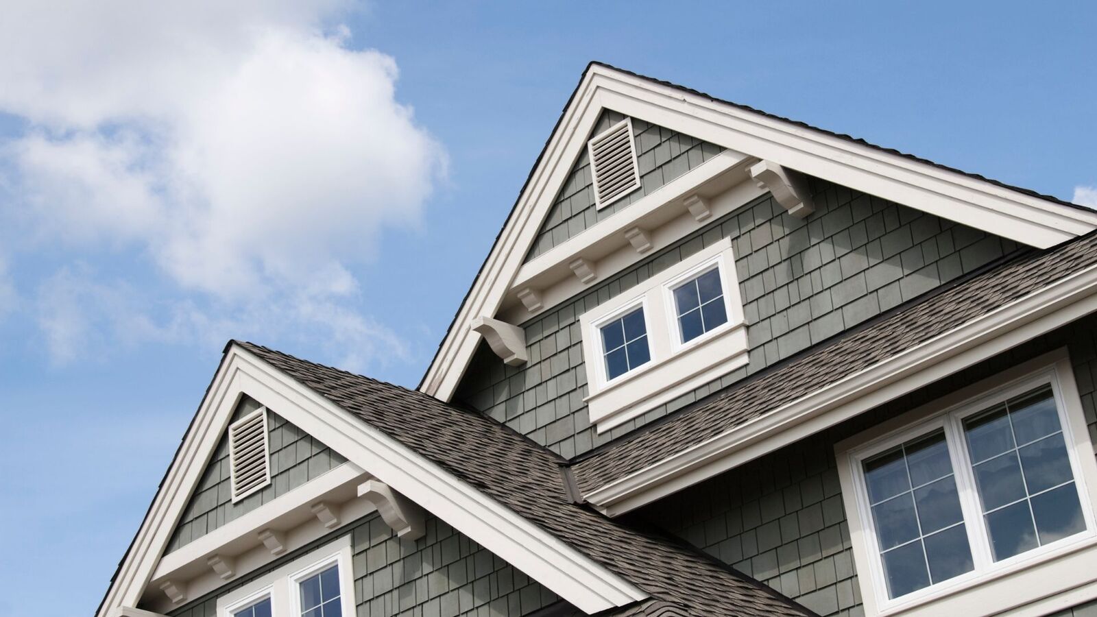 Architectural shingles on steep roof gables of a two-story home