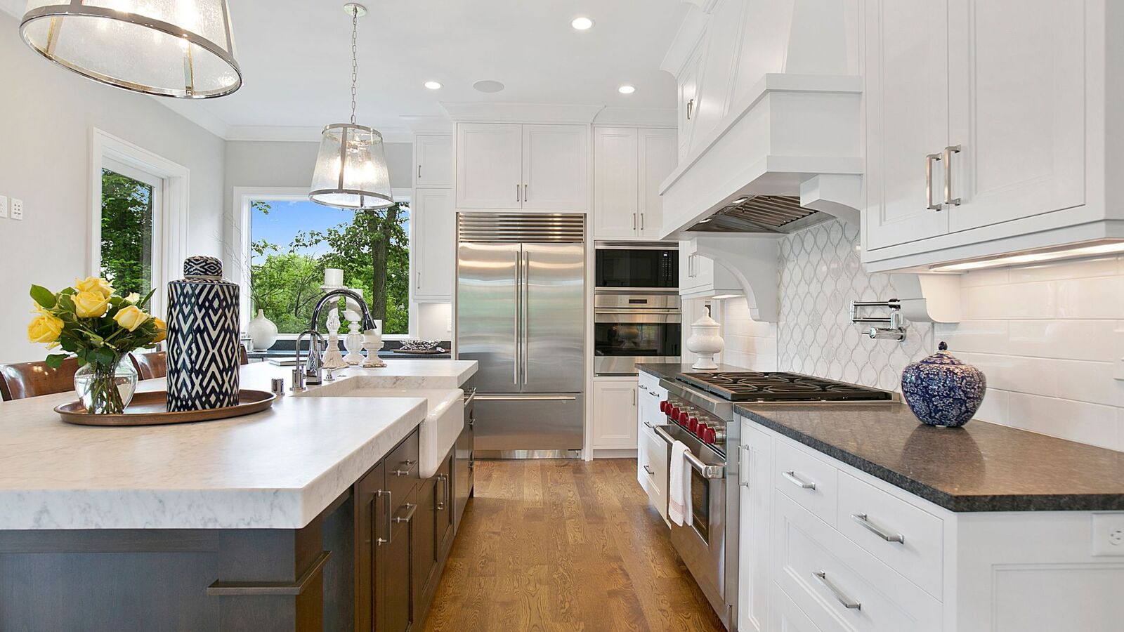 White kitchen remodel with farmhouse sink and quartz island