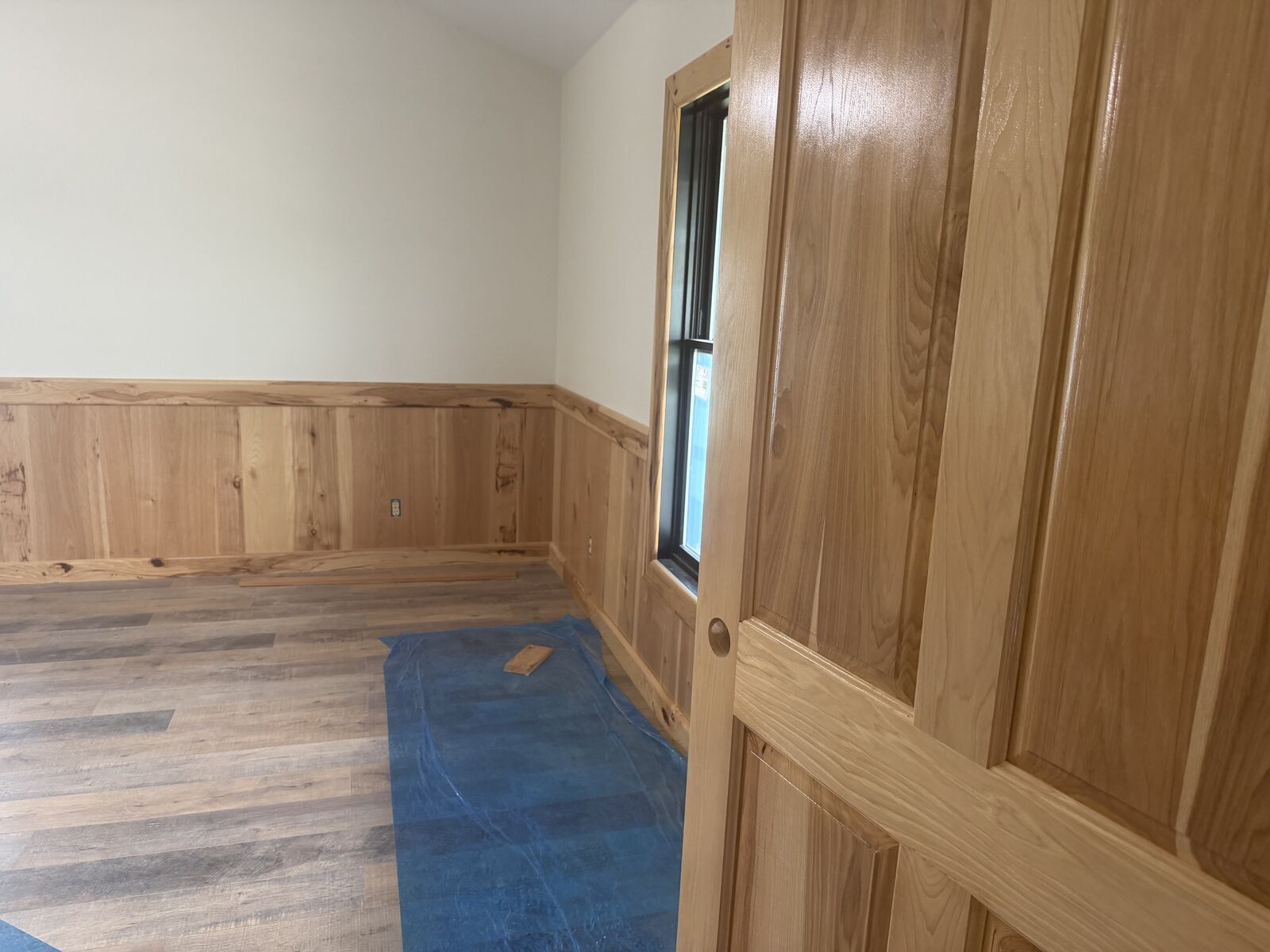 Bedroom remodel with hickory wainscoting and luxury vinyl plank flooring in Oklahoma